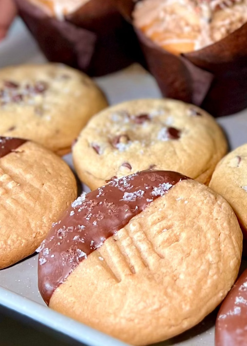 Assorted cookies,  muffins, and biscuits on a tray.